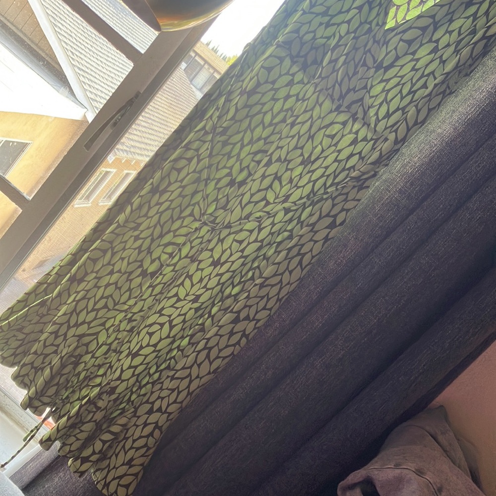 Dress green with brown patterns.small ruffle style at the bottom.